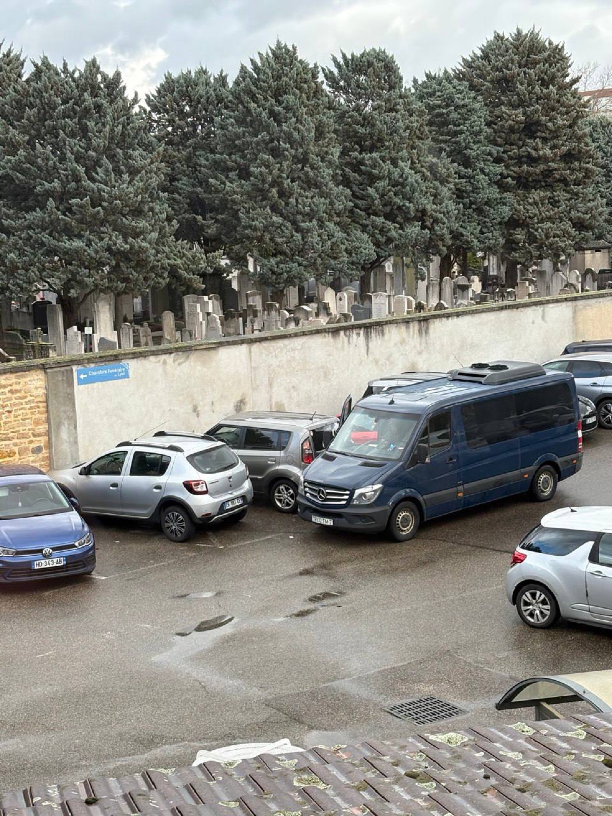 Катафалк у кладбища с указателем Chambre Funéraire de Lyon